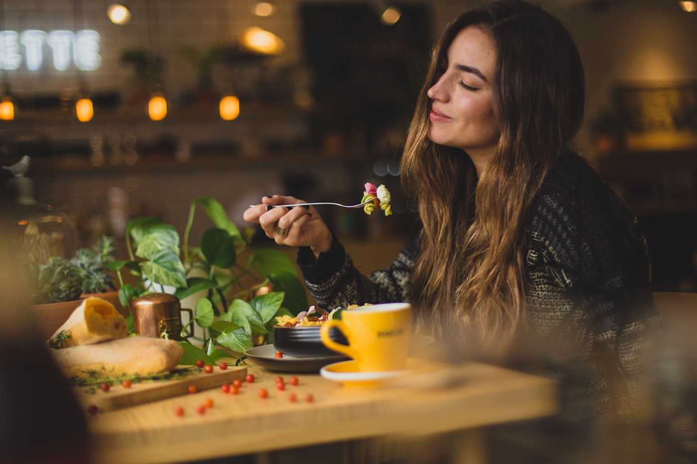 Gedeckter Frühstückstisch mit Keramik, Brot und frischem Obst